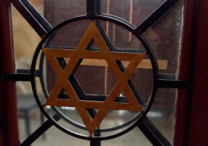 drzwi wewnętrzne do synagogi z witrażem i zdobieniami gwiazdą Dawida